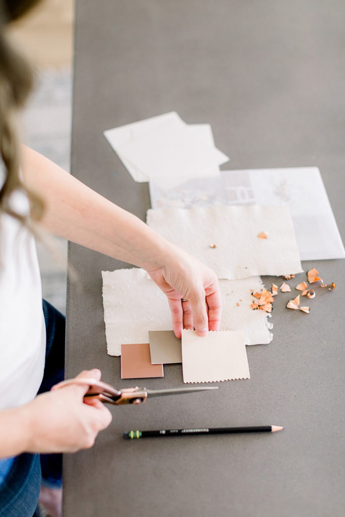 A brand designer cuts out paper