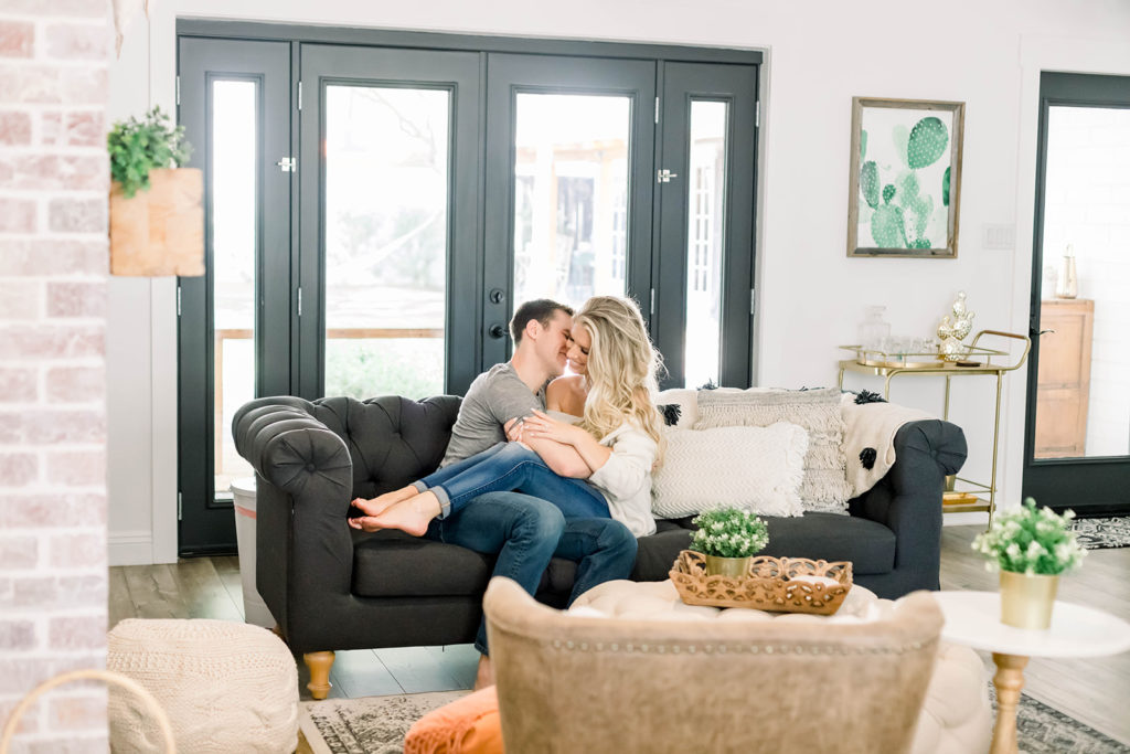 A young couple kisses on the couch